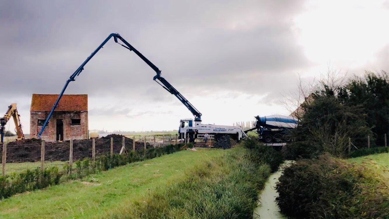 Betonpomp met arm van 36 meter over een gracht