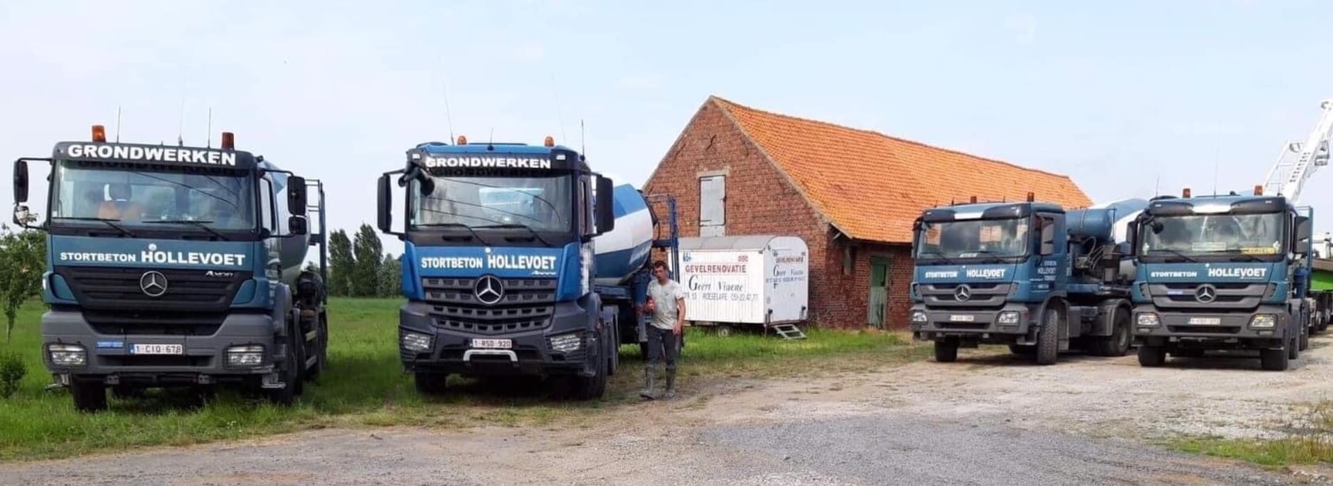 De vloot van Stortbeton Hollevoet op een rij naast de hoeve